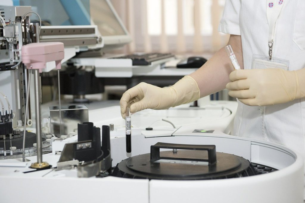 Hand wearing surgical gloves doing lab work in the laboratory